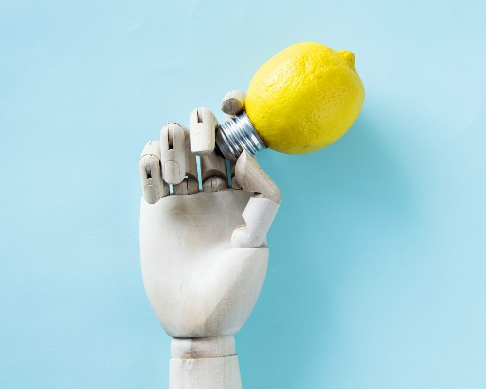 Robot hand holding a lemon bulb
